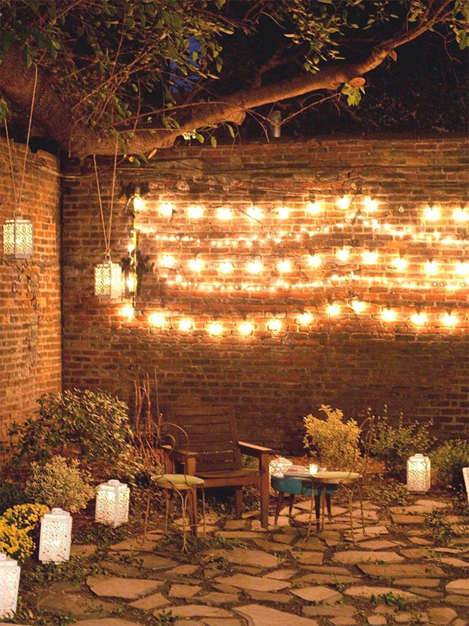 beautiful string lights on patio brick wall