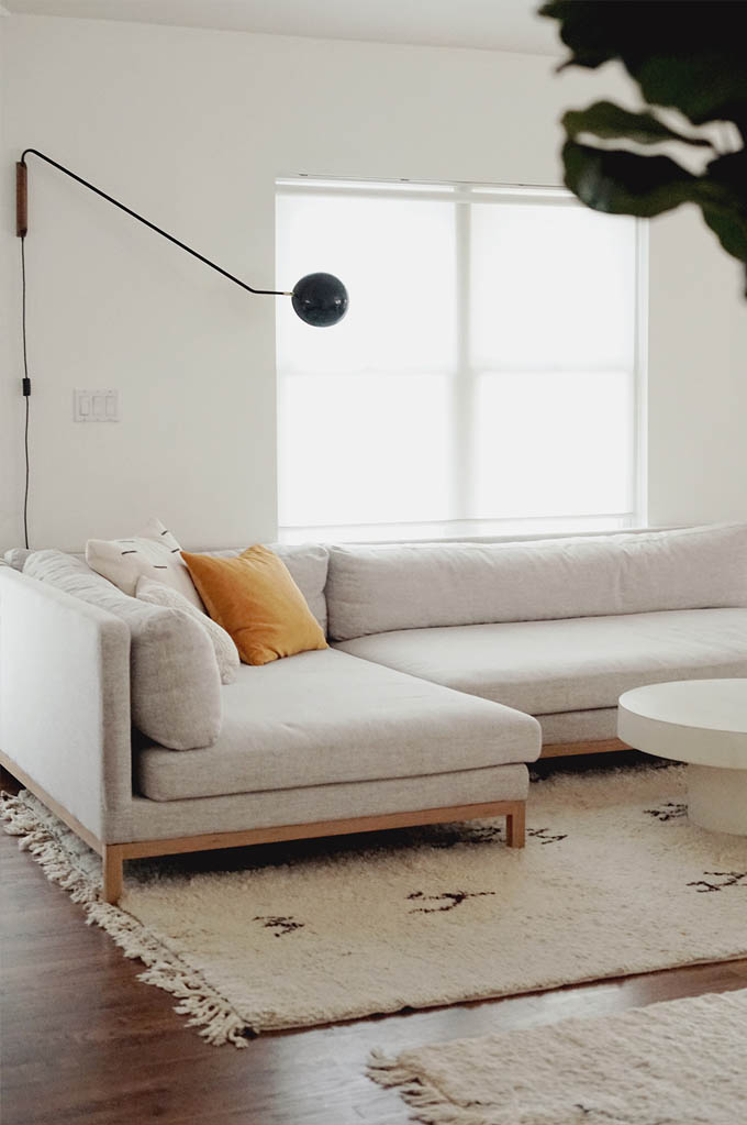 minimalist style living room with neutral sofa and neutral rugs