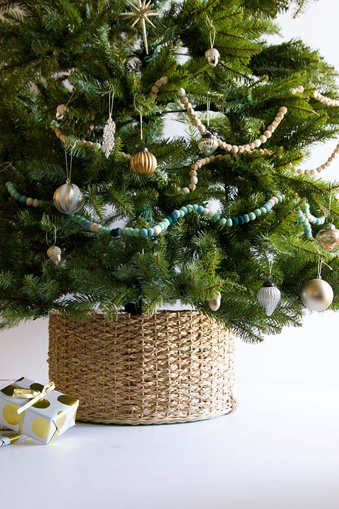 Neutral and wood christmas tree ornaments paired with a woven tree collar