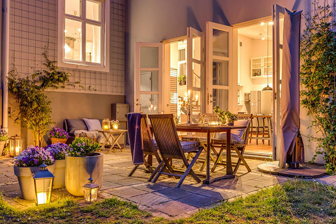 a truly hygge outdoor setting - candles, warm inviting lighting, blankets - looks like the perfect summer evening