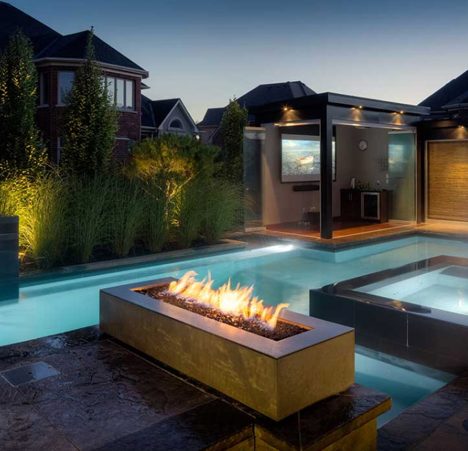 beautiful fire pit in front of a pool setting are a great way to add drama to your pool area