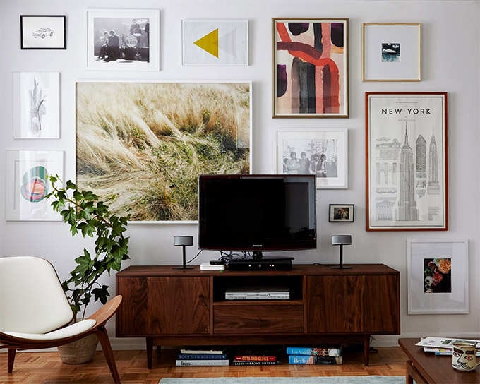 free flowing gallery wall layered behind the tv screen and console