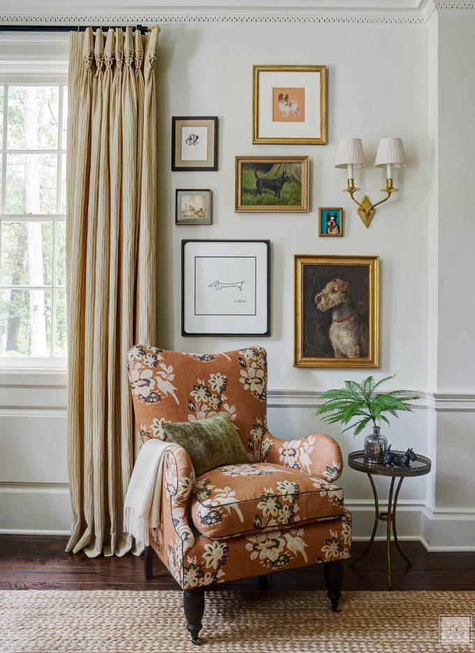 traditional interior vignette featuring floral accent chair with jute rug and traditional artwork and curtains
