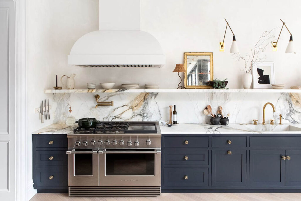 blue kitchen with marble counters and backsplash