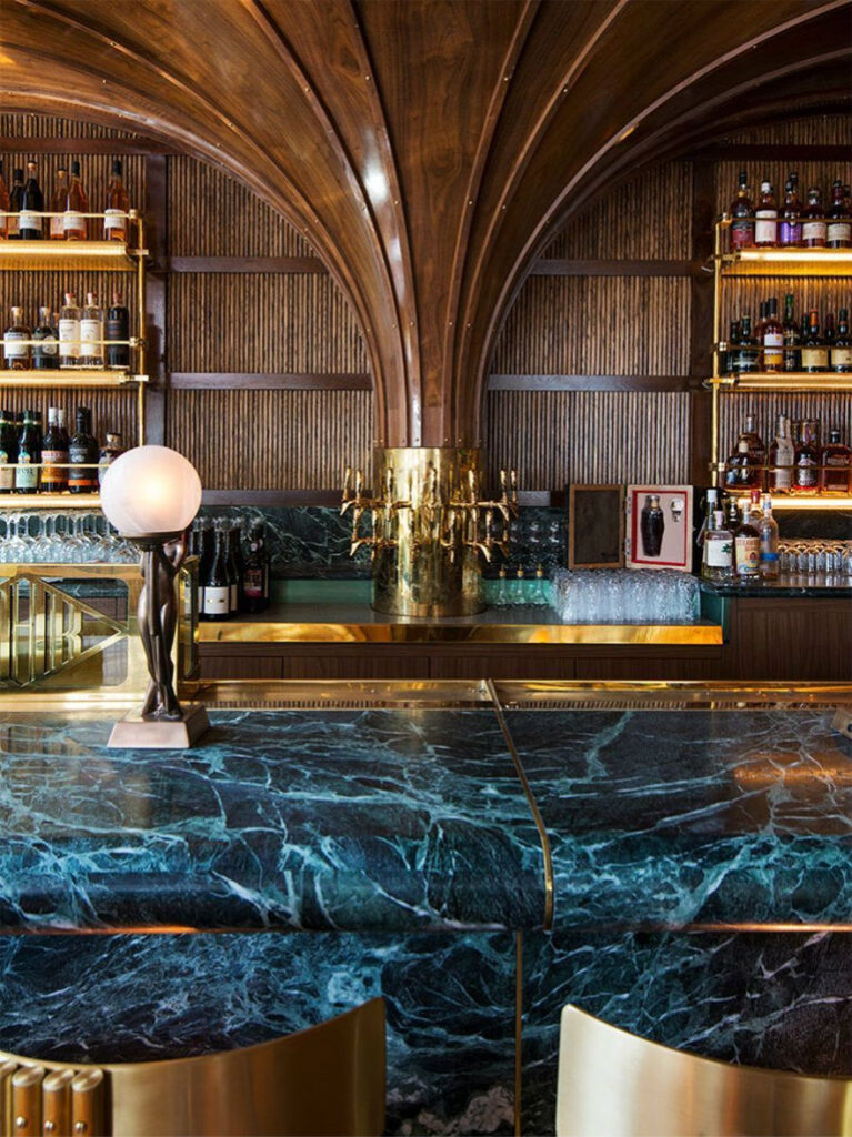 art deco inspired bar with luxurious materials like walnut and blue marble and brass accents