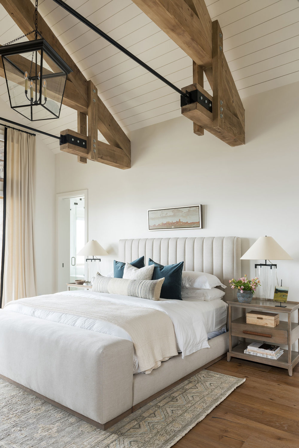 studio mcgee bedroom painted in white dove with large structural wood beams in ceiling