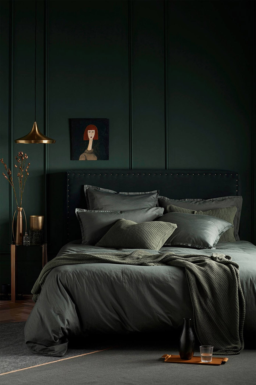 dark monochromatic green moody bedroom with brass accents
