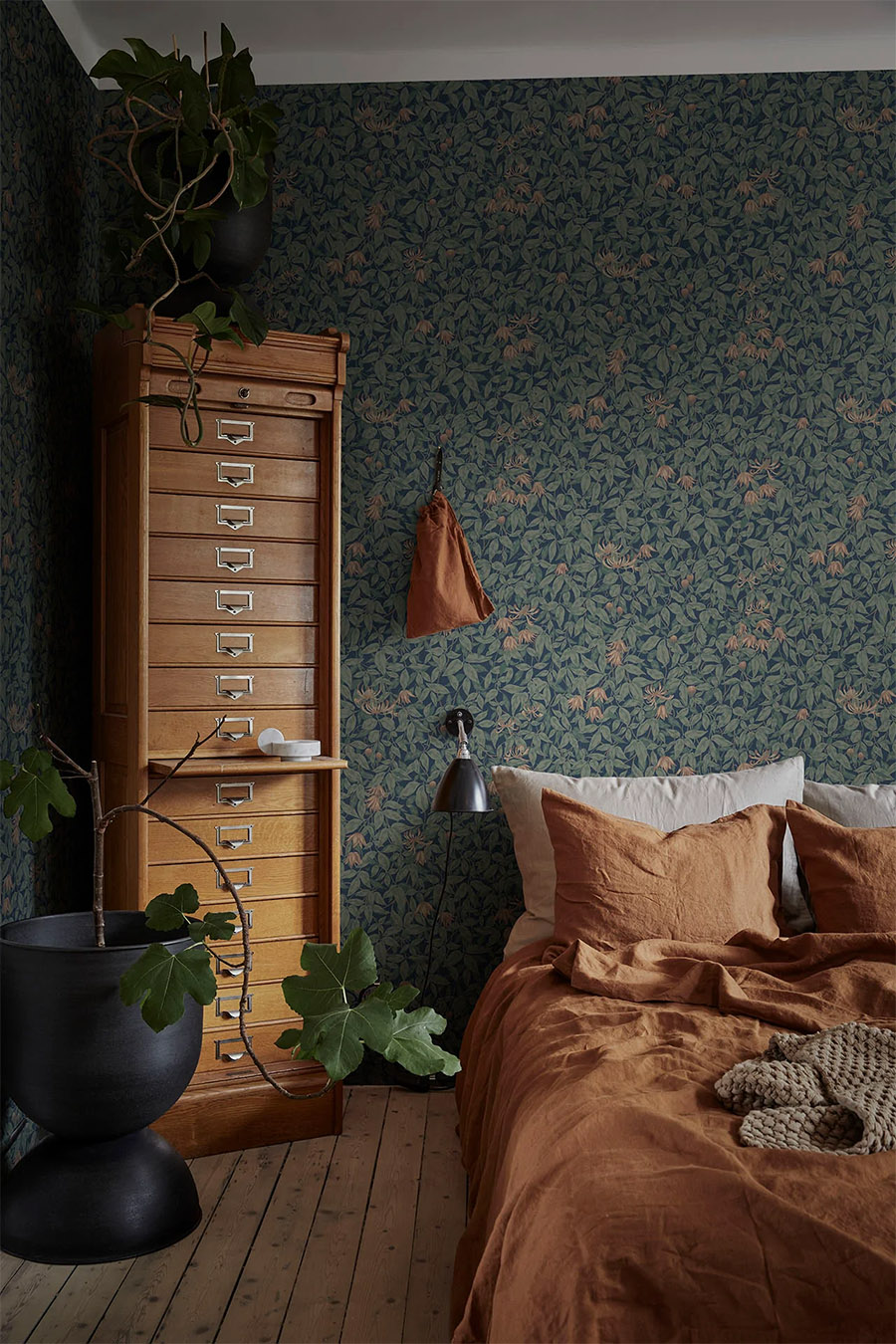 green floral wallpaper in bedroom with mustard and wood accents