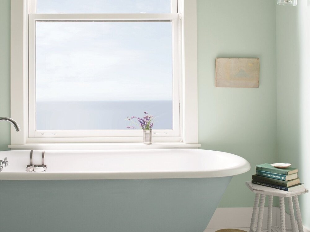 a bathroom with the walls painted in bm palladian blue, and the bath tub painted in bm breath of fresh air 