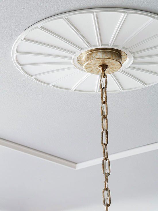 A beautiful contemporary white ceiling medallion adds character to a builder grade home